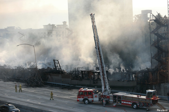 Fire crews work on smoldering hot spots of a large fire that consumed an apartment building that was under construction in Los Angeles